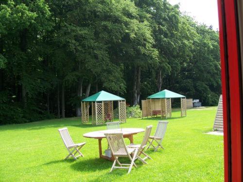 a picnic table and chairs in a grassy area at Econo Motel Goelzer in Büchenbeuren