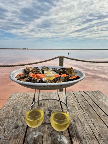 - un plateau de nourriture sur une table avec deux verres de vin dans l'établissement Soleil Marin à Gruissan Village, à Gruissan