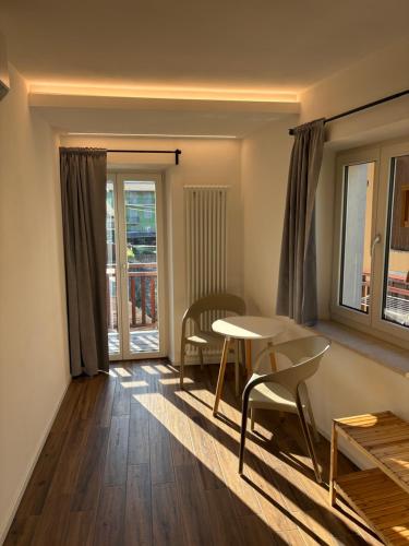 a living room with a table and chairs and a window at Casa Pitem in Nago-Torbole