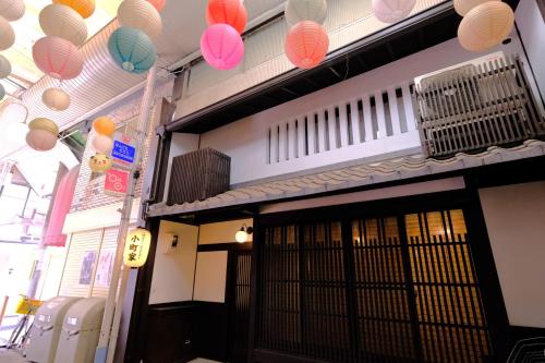 a building with colorful lanterns hanging above a door at Komachiya in Kyoto