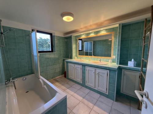 La salle de bains verte est pourvue d'une baignoire, de 2 lavabos et d'une baignoire. dans l'établissement Beautiful Villa, Quiet Sea View with Pool, à Saint-Raphaël