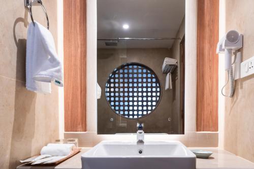 a bathroom with a white sink and a mirror at Temple Bell Boutique Hotel & Spa in Pokhara