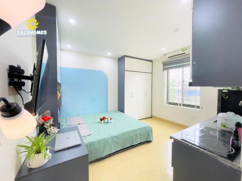 a room with a bed and a desk with a television at Dapano Maison in Hanoi