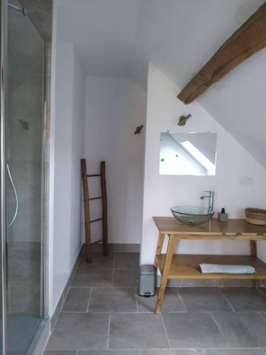 La salle de bains est pourvue d'un lavabo en verre et d'une douche. dans l'établissement Maison Prairie, à Argent-sur-Sauldre
