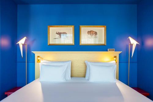 a blue bedroom with a bed with two lamps at Art Legacy Hotel Baixa-Chiado in Lisbon