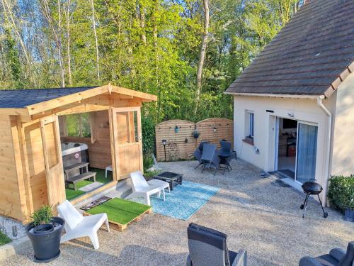un piccolo cortile con un capanno e sedie di Celies Country Cottage a Blaru