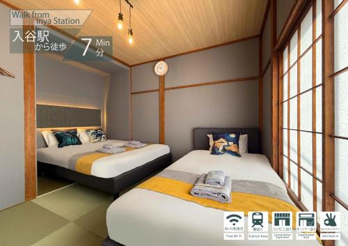 two beds in a small room with windows at nestay villa tokyo ueno in Tokyo