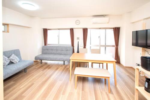 a living room with a table and a couch at レーヴk402 in Makishimachi