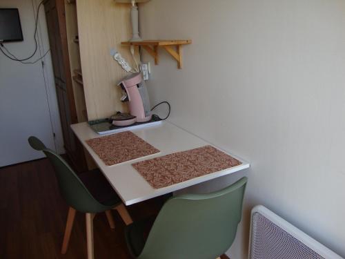 a table with two chairs and a pink appliance on it at MER à pied Vrai lit LINGE FOURNI Jardin LOCAL vélos in Brétignolles-sur-Mer