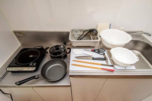 a kitchen counter with some utensils on a sink at レーヴk402 in Makishimachi