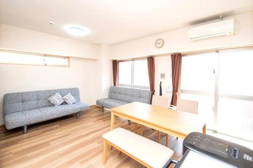 a living room with a couch and a table at レーヴk402 in Makishimachi