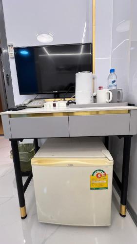 a desk with a computer monitor and a cooler at Golden Mango home hotel 金芒果之家酒店 in Bangkok