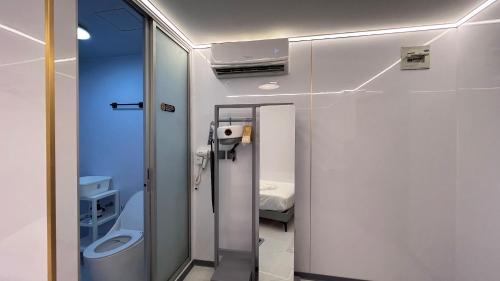 a bathroom with a toilet and a glass door at Golden Mango home hotel 金芒果之家酒店 in Bangkok