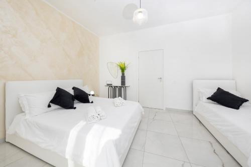 two white beds in a white room with white walls at A due passi in Capri