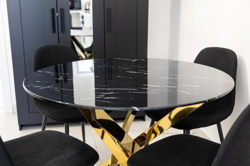 a black and gold dining table with black chairs at A due passi in Capri