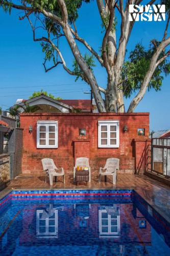 a house with a tree and a swimming pool at StayVista at Solea with BBQ, Bonfire, AC in Panchgani