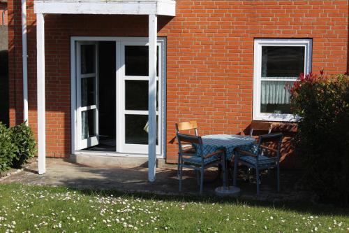 a table and chairs in front of a brick house at Ferien auf der Insel Poel in Kirchdorf