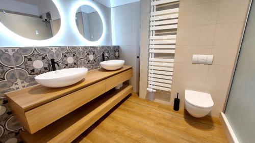 a bathroom with two sinks and a toilet at Villa Laetitia - by Rujana in Binz