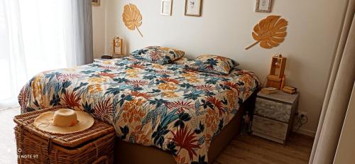 une chambre avec un lit avec un couvre-lit fleuri dans l'établissement Maison Pays des Abers Réservation exclusive à la quinzaine du 9 au 23 août 2025, à Plouguerneau