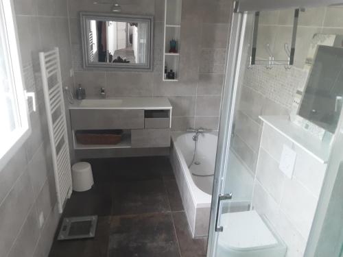 une salle de bain avec une baignoire, un lavabo et des toilettes dans l'établissement Maison Pays des Abers Réservation exclusive à la quinzaine du 9 au 23 août 2025, à Plouguerneau