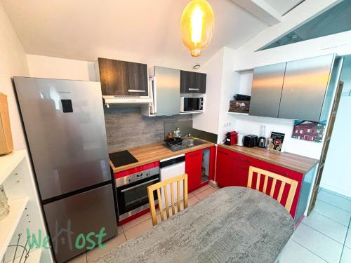 une cuisine avec des armoires rouges et un réfrigérateur argenté dans l'établissement Montalibet - CI - PB - 2 Nice house Parking, à Bayonne