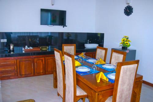 una mesa de comedor con sillas y una mesa con una servilleta azul y amarilla en Mountain View Villa Kurunegala, en Kurunegala