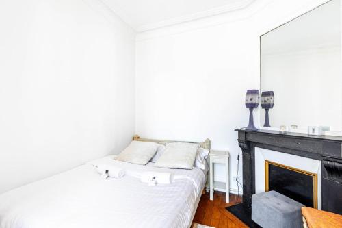 une chambre avec un lit et une cheminée dans l'établissement GuestReady - Gambetta Hideaway, à Paris