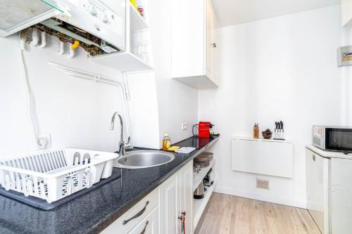 une cuisine avec un évier et un plan de travail dans l'établissement GuestReady - Gambetta Hideaway, à Paris