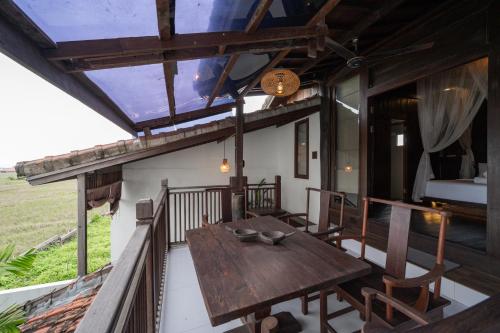 a wooden table on the balcony of a house at The Lavana Villa Ulin Cemagi in Canggu