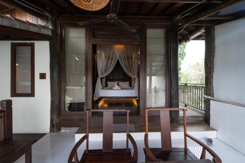a bedroom in a villa with a bed and two chairs at The Lavana Villa Ulin Cemagi in Canggu