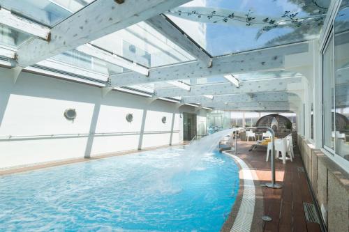 a swimming pool with a water slide in a building at Eurostars Louxo Talaso in Isla de la Toja