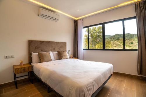 a bedroom with a large bed with a large window at Novaotel Malaga in Málaga
