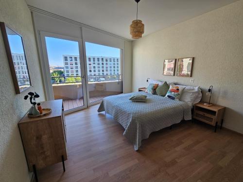 een slaapkamer met een bed en een groot raam bij Erlenmatt in Bazel