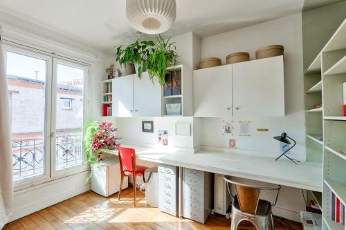 un bureau avec un grand bureau blanc et des chaises rouges dans l'établissement 2 pièces Contemporain - La Chapelle Paris 18 - 2P, à Paris