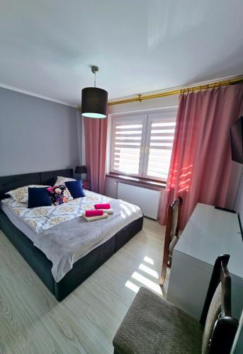 a bedroom with a large bed with pink curtains at Jagiellończyk in Sulejów