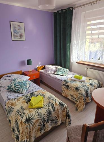 a bedroom with two beds and a table and a window at Jagiellończyk in Sulejów