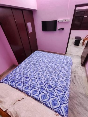 a bedroom with a bed with a purple wall at La Vonto - Madurai Railway Junction in Madurai