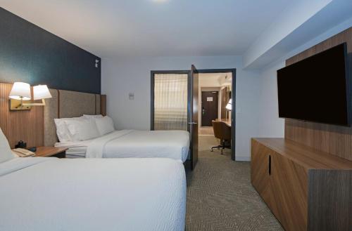 a hotel room with two beds and a flat screen tv at Holiday Inn Hotel and Suites-Kamloops by IHG in Kamloops