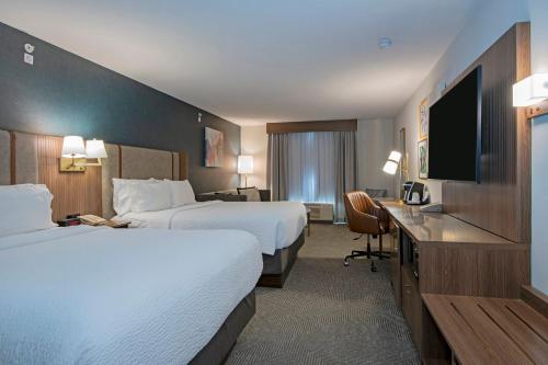 a hotel room with two beds and a flat screen tv at Holiday Inn Hotel and Suites-Kamloops by IHG in Kamloops