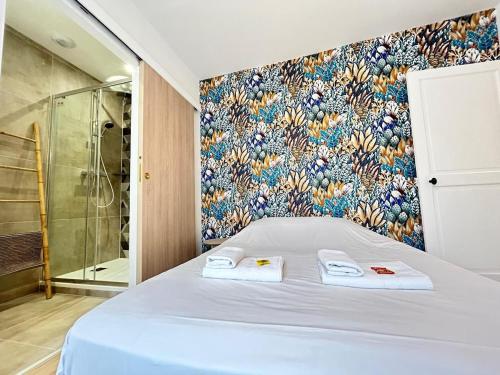 - une chambre avec une douche et un lit avec des serviettes dans l'établissement Chamonix magnifique duplex avec terrasse au centre, à Reims