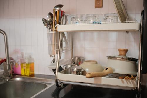 a kitchen sink with a shelf with utensils at Glory 2 Hue Homestay in Hue