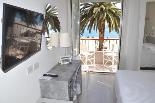 a bedroom with a bed and a view of the ocean at Hotel Boncardo in Finale Ligure