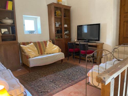 un salon avec un canapé et une télévision dans l'établissement La Bastide des Chênes Lacoste, à Lacoste