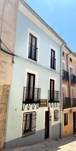 a white building with black balconies on a street at ATENEO CUENCA Suites con cocina en el casco histórico in Cuenca