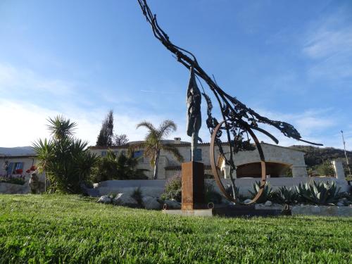 a metal sculpture in the grass in front of a house at Les 4 éléments in Tourrettes-sur-Loup