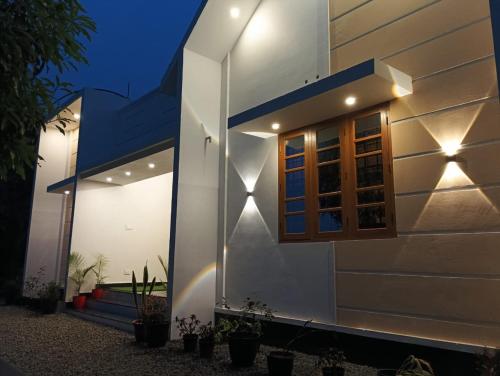 uma casa branca com uma janela à noite em Heaven Meadows Homestay Vagamon em Vagamon