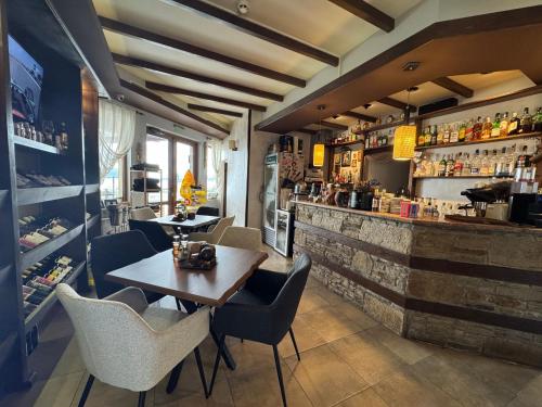 a restaurant with a table and chairs and a bar at Family Hotel Eterno in Tsigov Chark