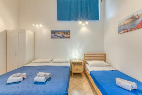 two beds in a room with blue sheets and towels at Casa Salento Pamela in Acquarica del Capo