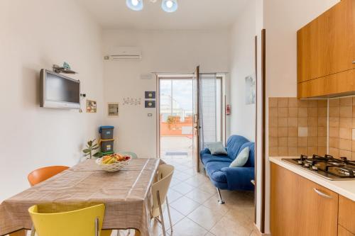 a kitchen and dining room with a table and a blue couch at Casa Salento Pamela in Acquarica del Capo