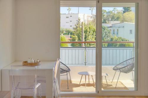 une chambre avec un balcon avec une table et des chaises dans l'établissement studio lumineux refait en 2025 a neuf A0B206, à Cannes